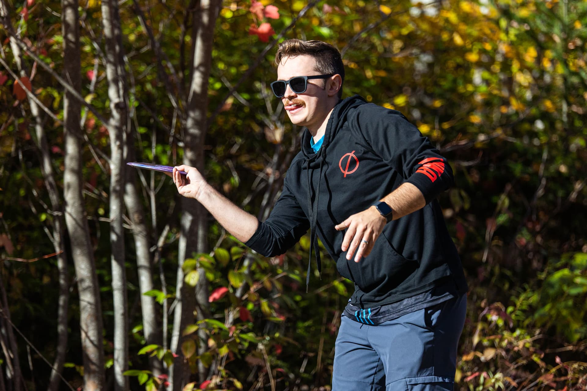 Close-up holding a disc in grip stance under autumn sunlight
